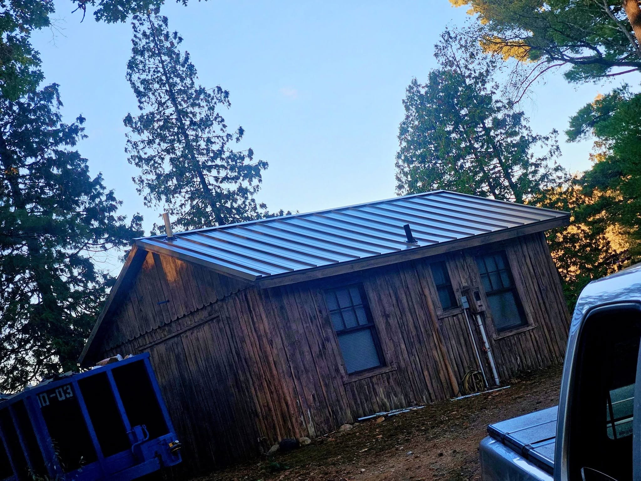 Standing seam metal roof on a rustic wooden building by A-Z Roofing